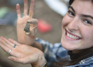 Charlotte Vaillancourt, étudiante de premier cycle, montre un outil en pierre taillée fraîchement découvert lors des fouilles archéologiques au lac Leamy.