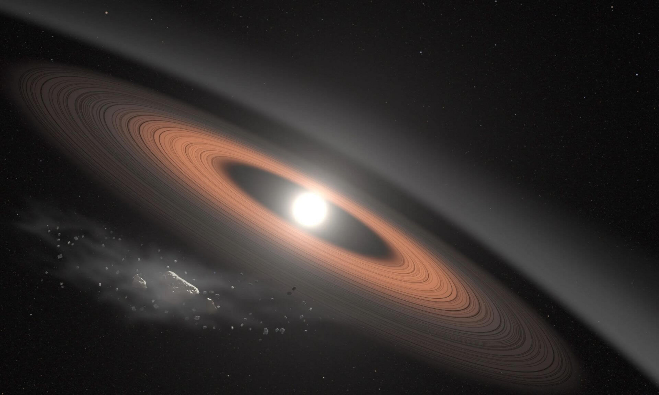 Sur cette illustration, un astéroïde (en bas à gauche) se fragmente sous l'effet de la puissante gravité de LSPM J0207+3331, la naine blanche la plus ancienne et la plus froide connue à être entourée d'un anneau de débris poussiéreux. Les scientifiques pensent que le signal infrarouge du système s'explique principalement par deux anneaux distincts composés de poussière apportée par l'effondrement des astéroïdes.