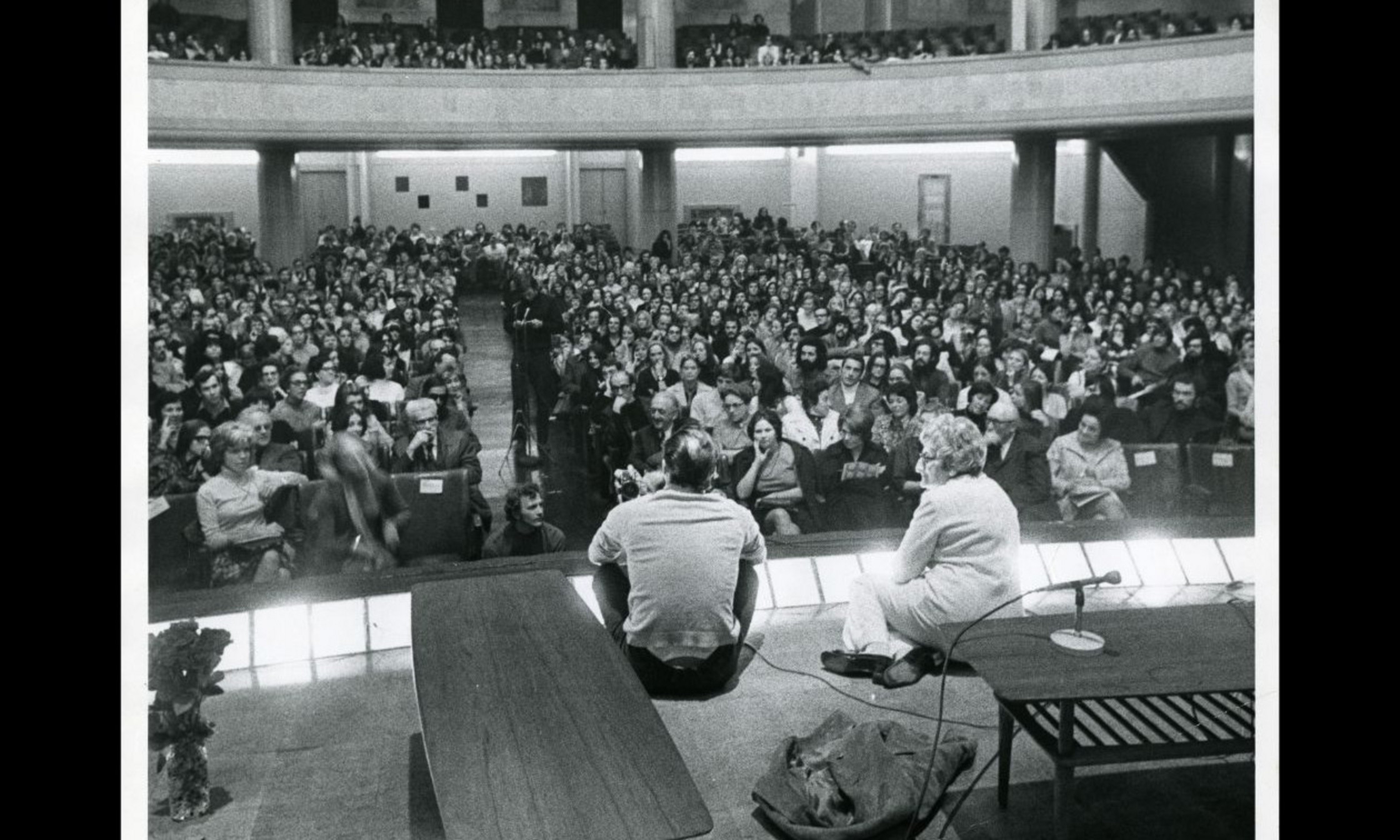 Maryvonne Kendergi assise avec Maurice Béjart lors d’un Musialogue à l’Université de Montréal, 1970. 1 photographie: épreuve n&b.