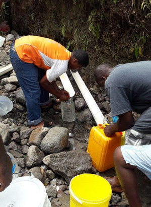 Photo prise en septembre 2017 après l’ouragan Maria, qui montre que les gens doivent trouver une source d’eau potable car les systèmes d’adduction d’eau ont été détruits